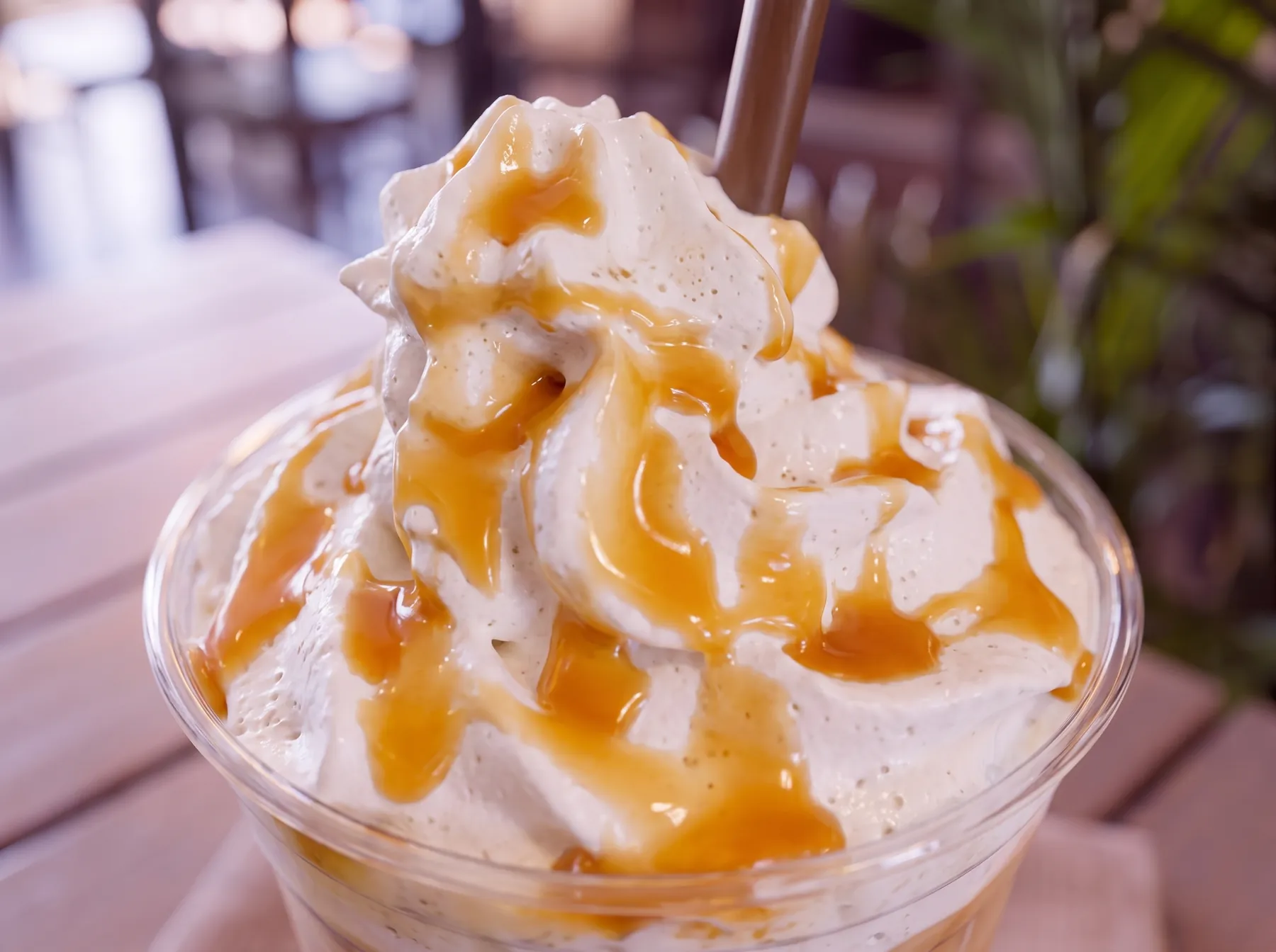 A caramel frappe under whipped cream and drizzle.