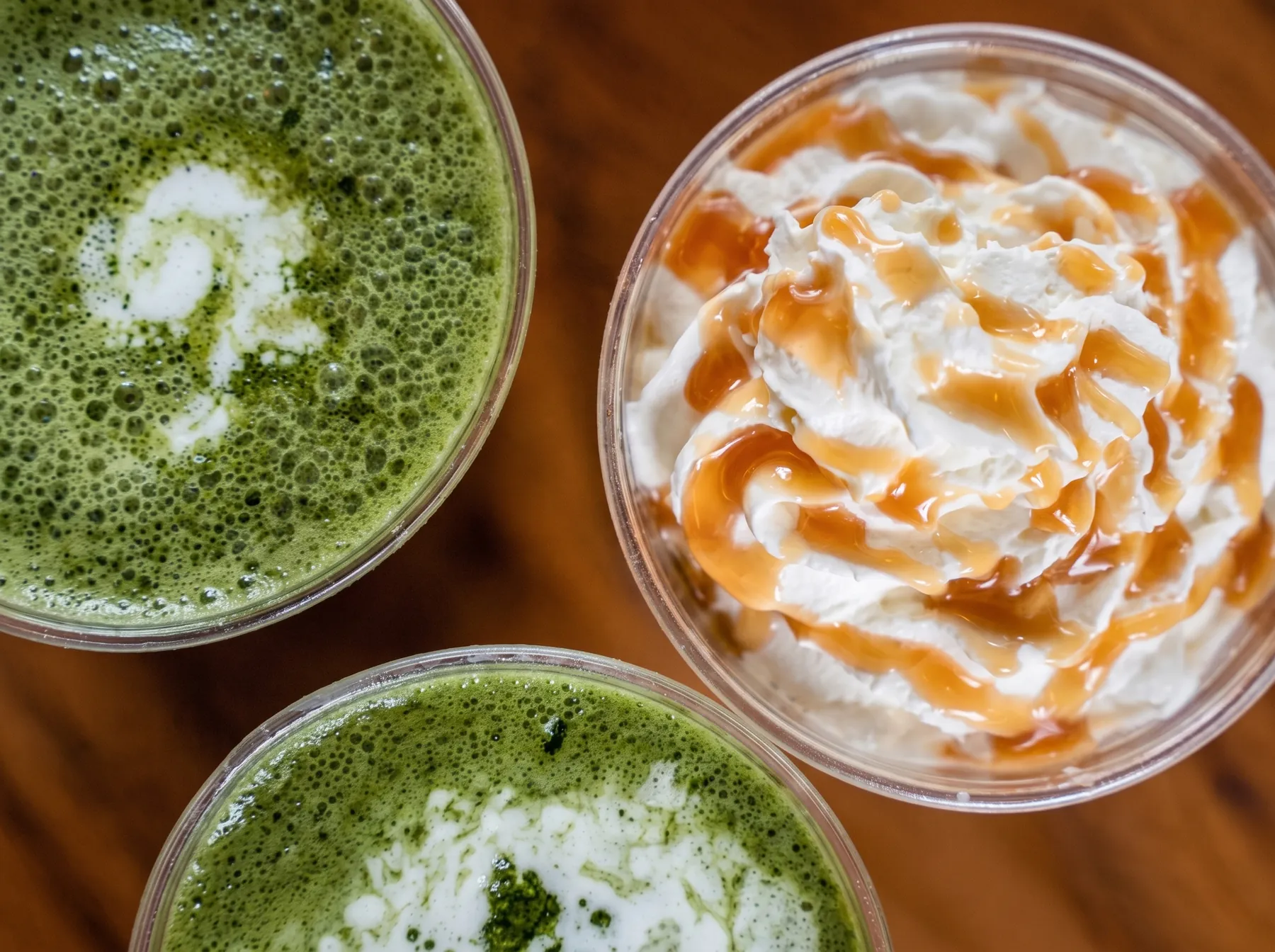 Two matcha lattes and a caramel frappe from above.