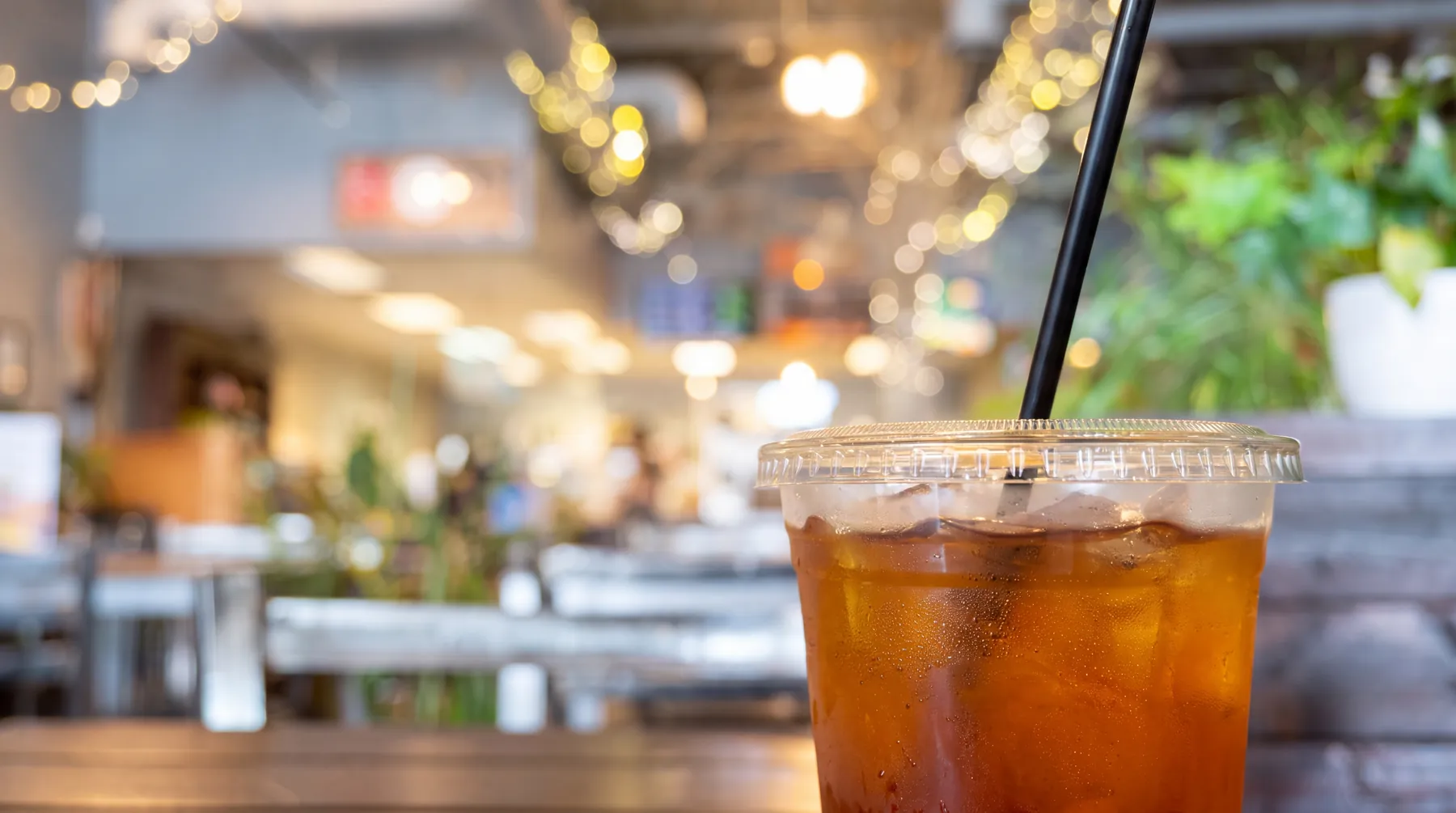 An iced Korean tea with a straw, the room behind it.