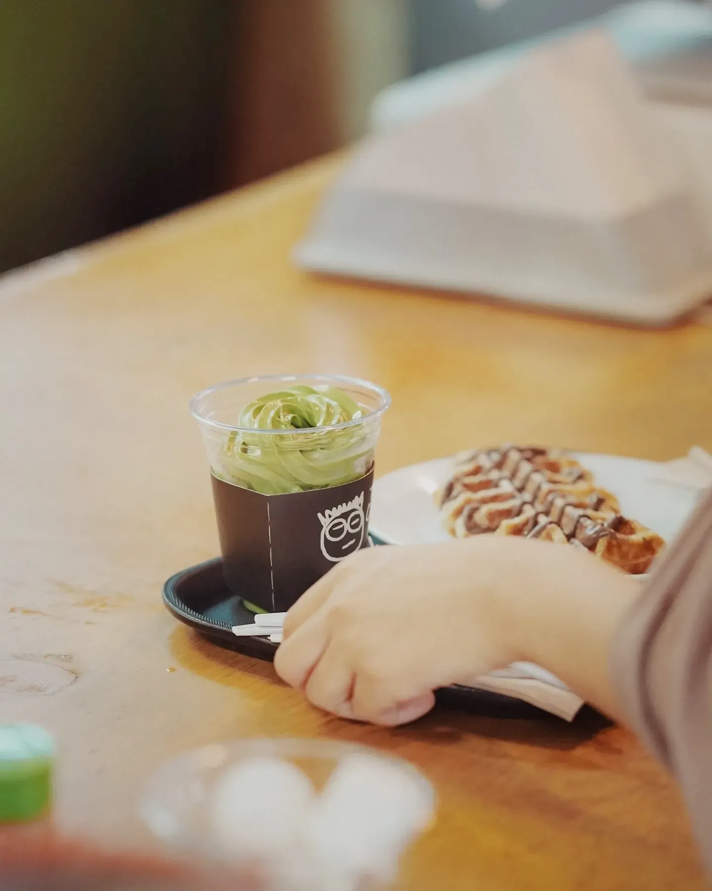 A matcha and a croffle on the wood table.
