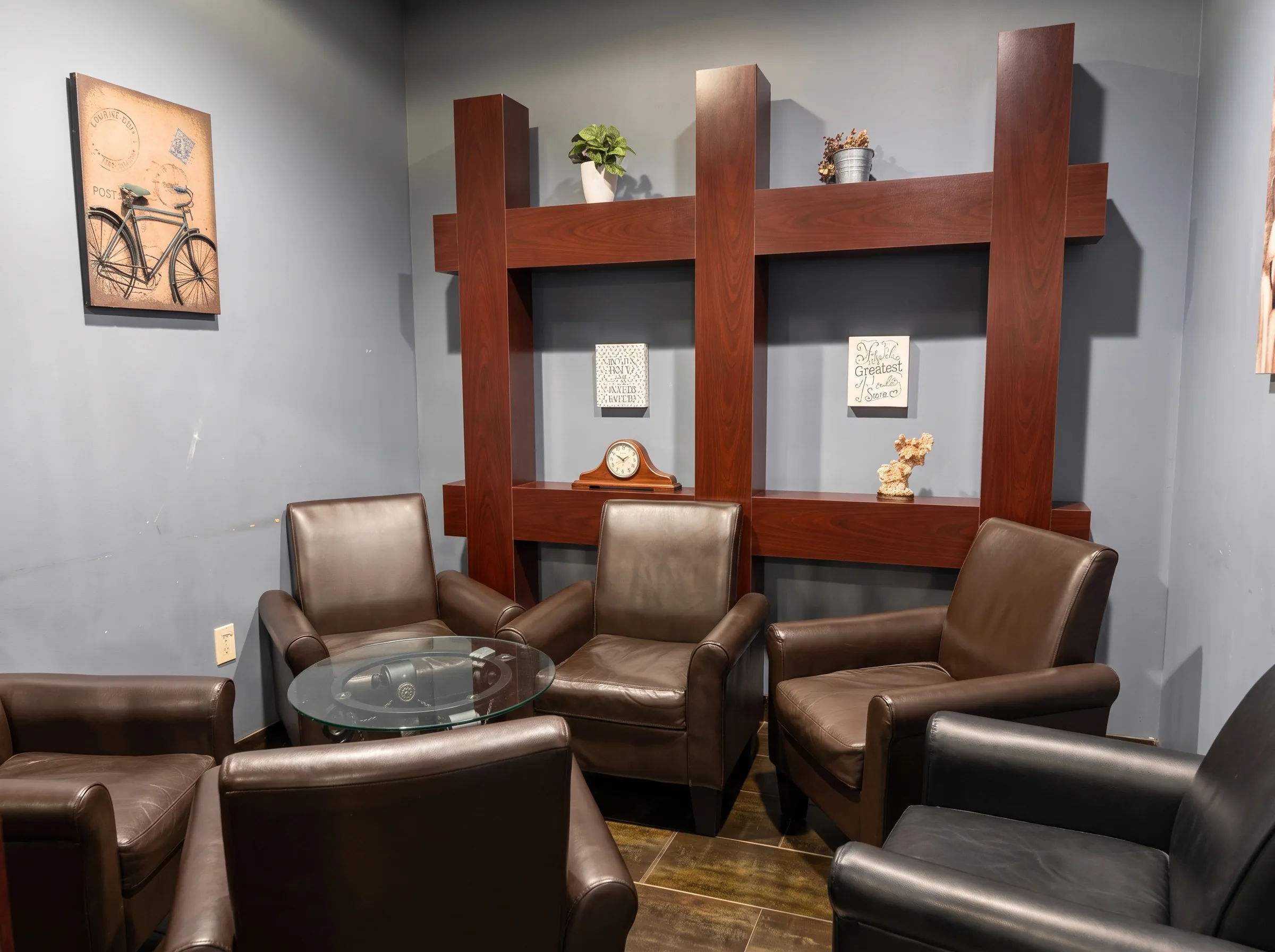 Leather armchairs behind the room's wooden dividers.