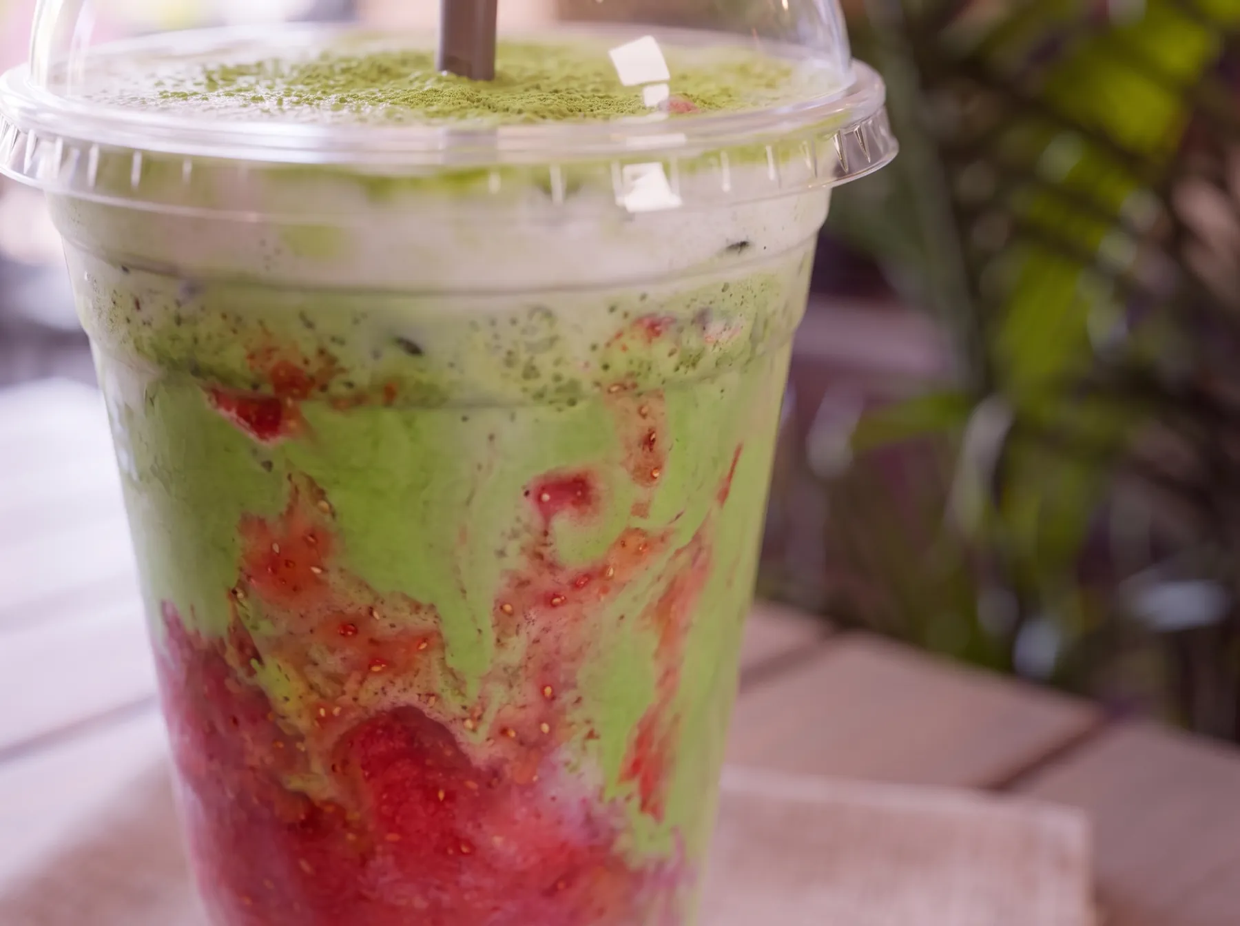 A strawberry matcha latte, layered red and green.